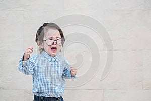 Closeup sad asian kid cry because he want something on marble stone wall textured background with copy space