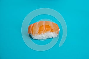 Closeup of a sake nigiri sushi or salmon sushi on a blue surface photo