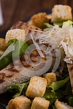 Closeup of a salad bowl with lettuce bread cheese and grilled chicken photo