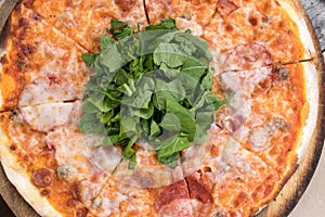 Closeup of salami pizza with ruccola, detailed.