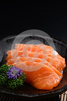 Closeup salmon sashimi on black plate. Japanese food style concept