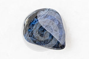 Polished Dumortierite rock on white marble photo