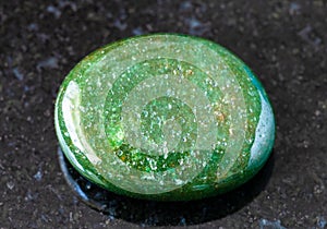 polished green Aventurine gem stone on black photo