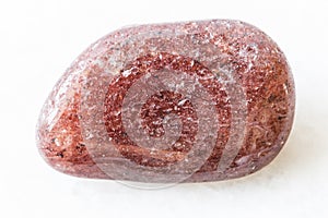 Polished red aventurine gem stone on white marble photo
