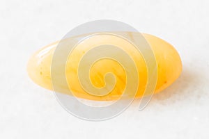 Polished yellow chalcedony rock on white marble