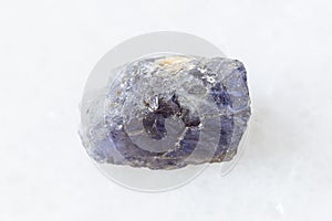 Rough Cordierite Iolite crystal on white marble photo