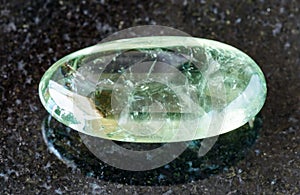 tumbled Prasiolite (green quartz) rock on black photo