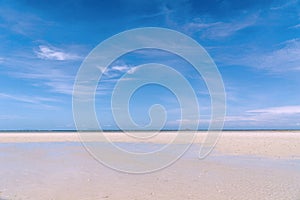 Closeup of sand on the beach and blue summer sky. Panoramic beach landscape. Empty tropical beach and seascape. Orange and golden