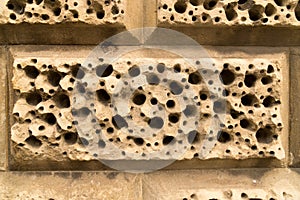 Closeup sandstone bricks wall decoration holes background