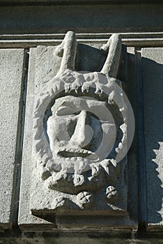 Closeup of a satyr statue on a stone wall