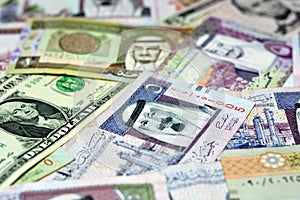 Closeup of Saudi Arabia riyals money banknotes with American dollars banknotes