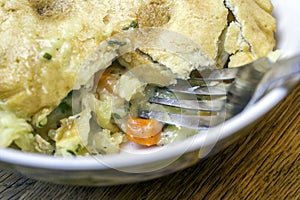 Closeup of savory chicken pot pie with fork in the crust