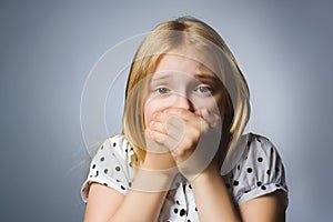 Closeup Scared and shocked little girl. Studio shot portrait over gray background. Human emotion face expression. Life