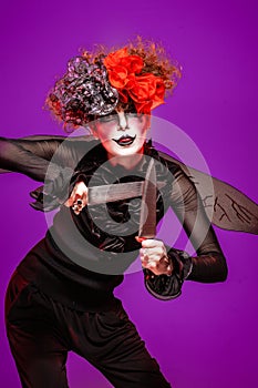 A closeup of a scarier clown female Holding Knife