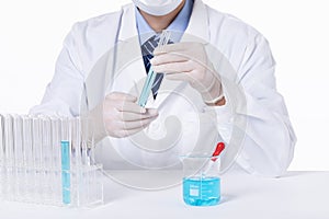 Closeup of a scientist experimenting with blue toxic substances in containers in a laboratory