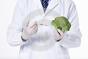 Closeup of a scientist injecting toxic substances to broccoli in a laborato