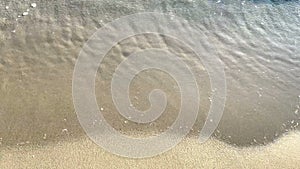 Closeup Of Sea Waves Washing Ashore A Sandy Beach