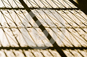 A closeup section Metal fence shadow on the sidewalk