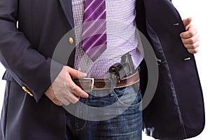 Closeup security agent in business suit with hand gun attached on belt. isolated on white