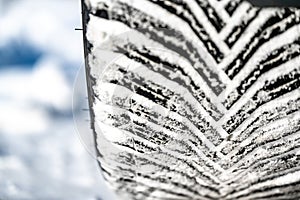 Closeup selective focus on snow packed in an all-weather tire tread.