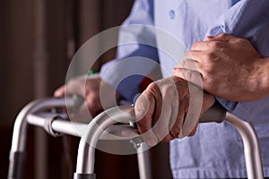 Senior man`s hands holding walker at nursing home