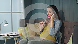 Closeup serious pregnant woman talking mobile phone at home office