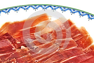 Closeup of serrano ham slices on a white dish