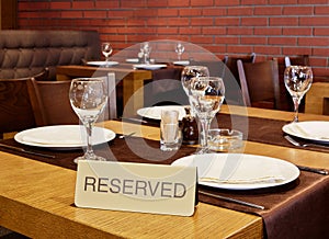 Closeup served table with sign Reserved in