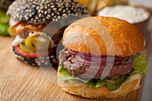 Closeup of set of three mini homemade Burger with marble beef and vegetables on a wooden Board