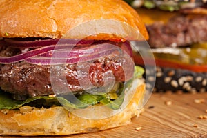 Closeup of set of three mini homemade Burger with marble beef and vegetables on a wooden Board