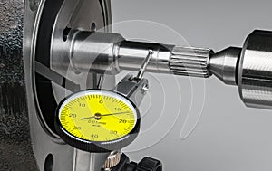 Closeup a shaft run-out measurement by yellow dial test indicator with metal probe on hinge and round tip