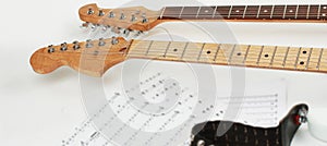 Closeup .sheet music and guitar on a white background.