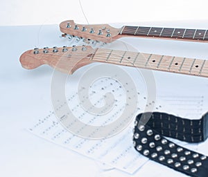 Closeup .sheet music and guitar on a white background.