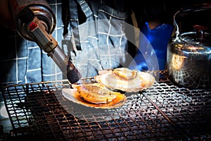 Closeup shell on grill. Action of burning shell by Butane torch.