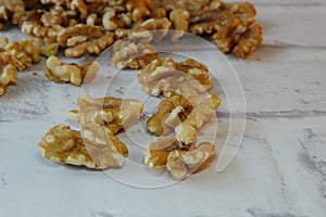 Closeup of shelled walnuts pile on the top of white table