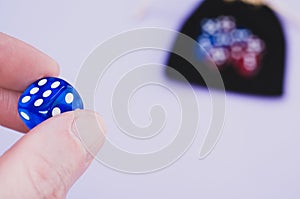 Closeup shoat of a hand holding blue dice isolated on white background