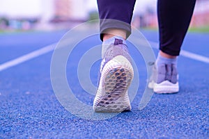 Closeup shoe. Female legs jogging and walking on the running track. Sport and exercise concept