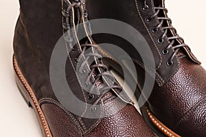 Closeup of Shoelaces of Premium Dark Brown Grain Brogue Derby Boots Made of Calf Leather with Rubber Sole Placed Over Beige