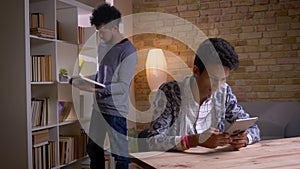 Closeup shoot of two culturally diverse students learning in the school library indoors. Indian male studying online