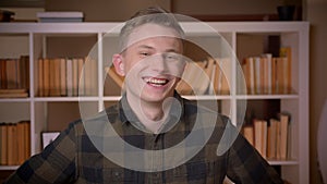 Closeup shoot of young attractive caucasian male student smiling and laughing cheerfully looking at camera in the