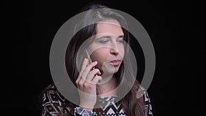 Closeup shoot of young attractiver caucasian female having a casual conversation on the phone in front of the camera