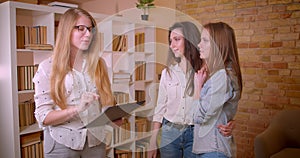 Closeup shoot of young beautiful lesbian couple talking to female realtor about purchase of an apartment