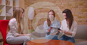 Closeup shoot of young beautiful lesbian couple talking to female realtor about purchase of an apartment shaking hands