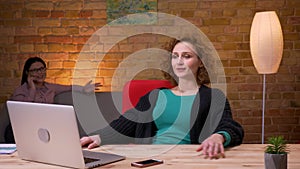 Closeup shoot of young businesswoman working on the laptop having a phone call and relaxing laidback indoors in the