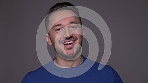 Closeup shoot of young handsome caucasian man being excited and surprised celebrating happily looking at camera with