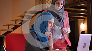Closeup shoot of young muslim businesswomen in hijabs working in a team together on the issue in front of the laptop