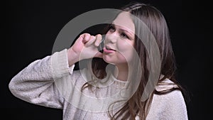 Closeup shoot of young pretty caucasian female having a casual conversation on the phone in front of the camera