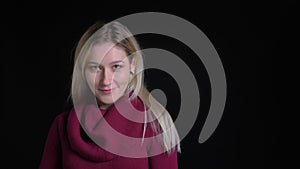 Closeup shoot of young pretty caucasian female looking at camera and smiling seductively posing in front of the camera