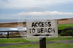 Closeup shot of access to beach sign pointing the way
