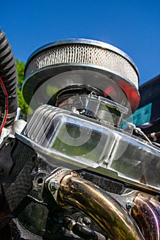 Closeup shot of an air filter of a retro car under a blue sky - technology